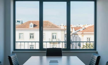 A professional interior shot of a modern, sun-drenched law firm meeting room in Portugal. Through the window, European architecture is visible. The composition is clean and symmetric, emphasizing transparency and clarity. Palette: medium blue and white.