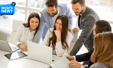 a group of people sitting around a table with laptops and a text saying What's New?