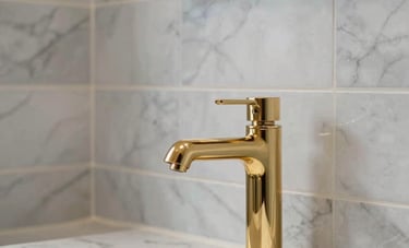 Detailed shot of high-end interior craftsmanship: perfectly aligned marble tiles in a bathroom and a gold-accented faucet. Luxurious, clean aesthetic with sharp focus and professional lighting.