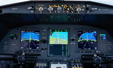 Detailed shot of a sophisticated aircraft cockpit glass display showing navigation maps and communication frequencies. The atmosphere is high-tech, featuring colors like dark navy and bright light blue.