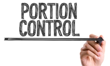 A hand writing the words Portion Control on a transparent glass board for diet and nutrition planning.