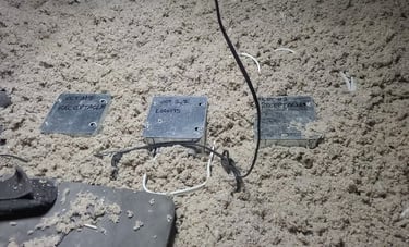 Electrical junction boxes for lights and receptacles installed in blown-in attic insulation.