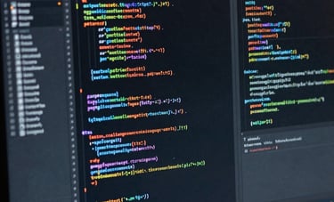 Close-up of a high-resolution computer screen displaying organized lines of computer code in a dark mode editor, reflecting professional software engineering. Global / International office setting.
