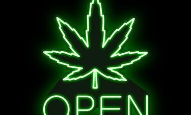 Dispensary storefront at night with open sign
