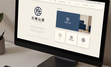 A close-up of a designer's desk in Rome, featuring a high-end monitor showing a modern logo construction and brand identity guidelines for an Italian Chinese luxury brand. Off-white and slate blue tones.