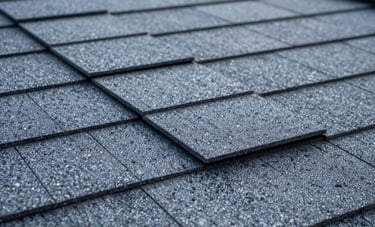 Professional macro photography of high-strength wind-resistant roofing shingles being installed on a New York City home. Sharp detail on the interlocking layers, cool storm gray and steel blue color palette, North American / US context.