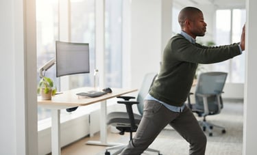 Person performing doorway chest stretch to improve flexibility after desk work.