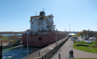The stern of a red and white ship as it exits Lock 3 at the Welland Canal.
