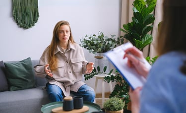 A woman sitting on a couch for a behavioral health consultation