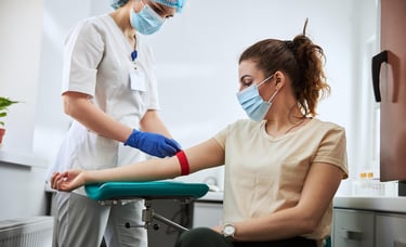 a woman preparing to get blood drawn by a nurse to perform labs