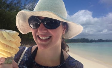 Autora saboreando abacaxi esculpido na praia de Mont Choisy, Port Louis, Ilhas Maurício.