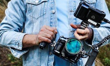 Mann in blauer Jeansjacke, draußen, mit Kamera Rig in den Händen, von vorne