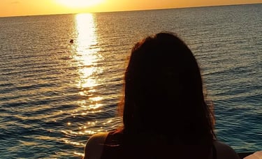 Silhouettes of tourists enjoying the serene Zanzibar sunset on a traditional dhow cruise.