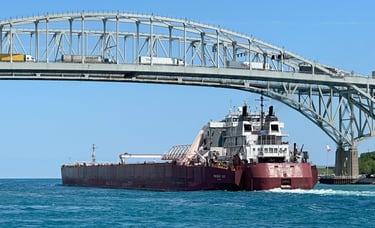 Huge red tug barge Presque Isle passes under the Blue Water Bridge.