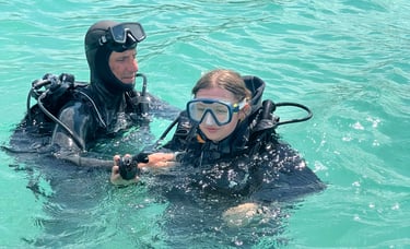 a man and woman in scuba gear in the water