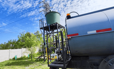 Camión aljibe llenando un estanque con agua potable