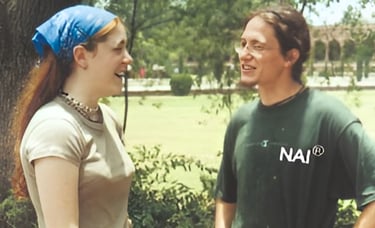 a man and woman standing in front of a tree