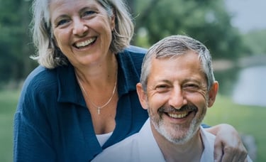 A happy senior couple smiling outdoors, representing healthy aging and retirement lifestyle.