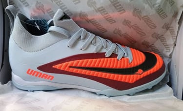 Zapatos de fútbol para césped artificial Uman en gris y naranja para superficies.