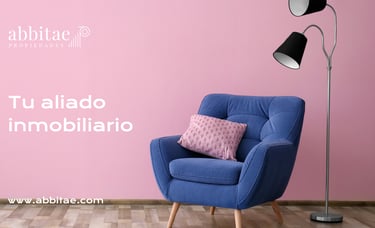 Una silla azul con una pared rosa y una lámpara.