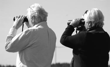 Älteres Paar von hinten, durch Ferngläser schauend