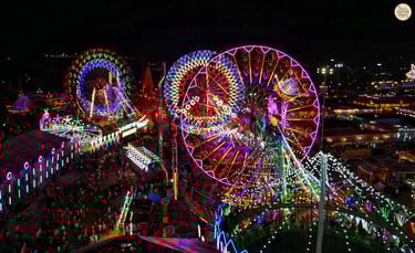 Night aerial view of Kota Dussehra Mela with glowing giant wheels, dazzling rides, and illuminated stalls.
