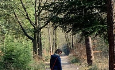 a person walking down a dirt road with a dog