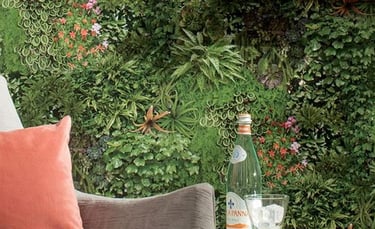 Modern living room featuring a vertical garden wall behind a grey armchair with an orange cushion.