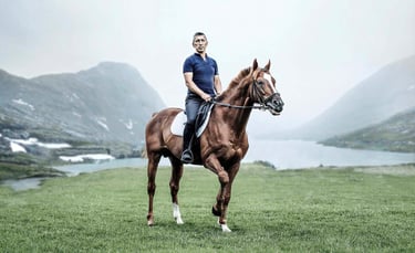 A rider on a horse in a mountain setting, embodying elegance and adventure for an equestrian brand.
