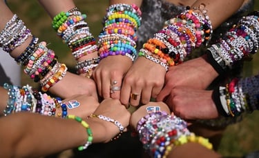 Fans exchanging colorful friendship bracelets at Taylor Swift Eras Tour.