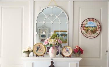 a vase with flowers on a mantle