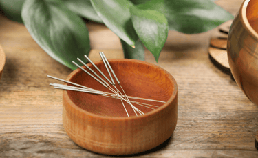 Aiguilles d'acupuncture dans un bol en bois, bol tibétain à coté