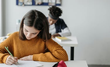 a woman in a yellow sweater is writing