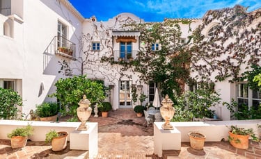 Rustic Spanish villa for rent featuring a charming ivy-covered patio