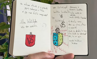 Uma pessoa segurando um livro com desenhos e anotações para brasão/logotipo;