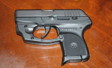 Ruger LCP with laser laying on a wood table