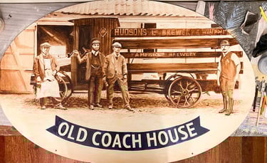 Close-up of pub sign with painted brewery staff