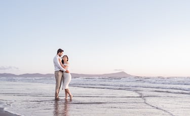 a man and woman standing in the ocean