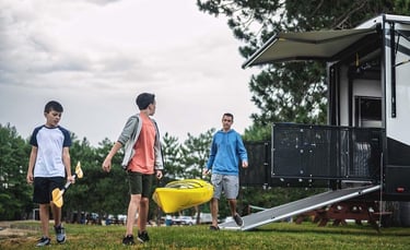 a group of people walking around a trailer carrying a canoe