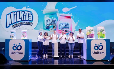 Unifam team launching Milkita Milky Pudding products on stage with digital background and banners.