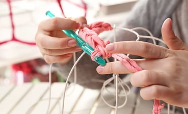 Persona tejiendo con gancho y estambre de crochet
