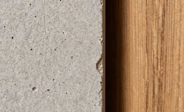 Macro shot of high-quality light gray stone texture next to a warm oak wood plank, representing the premium materials used by HCI.