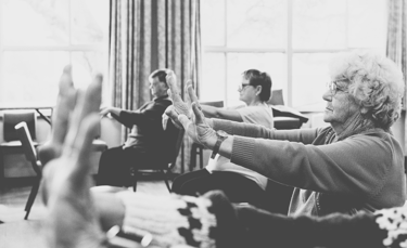 Chair Yoga class hands raised and wrists bending