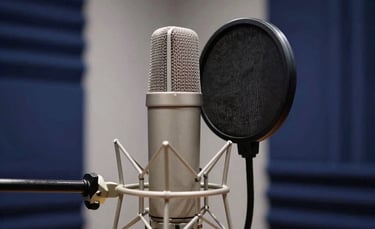 A high-end recording studio environment in a Global / International city, featuring a sleek large-diaphragm condenser microphone with a silver pop filter, deep navy blue acoustic wall panels, and soft white studio lighting, minimalist and professional.