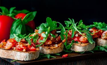 Traditionelle italienische Tomaten-Bruschetta mit frischem Rucola und Basilikum auf geröstetem Brot.