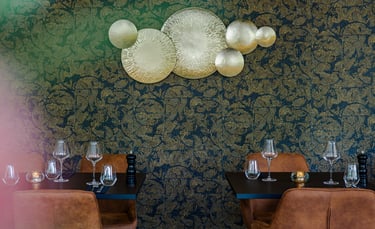 Elegantes Fine-Dining-Restaurant mit goldenen Wandakzenten und Ledersitzen.