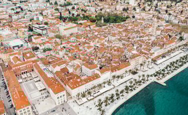 Aerial view of Split, Croatia, showing old town terracotta roofs and the Riva waterfront promenade.
