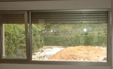 Ventana oscilobatiente con fijo y lamas de persiana.