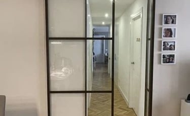 Puerta de interior corredera de una hoja en hierro con cuarterones.