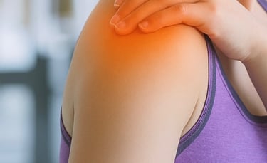 Person experiencing shoulder pain with visible inflammation, indicating symptoms.
